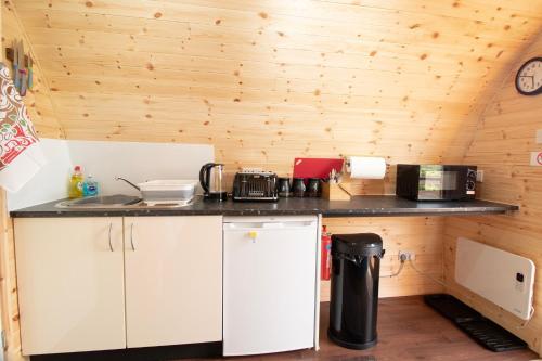een keuken met houten wanden en een aanrecht bij Breakish Bay Pods in Breakish