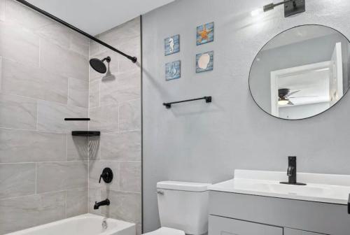 a bathroom with a toilet and a sink and a mirror at Clearwater Charm in Clearwater