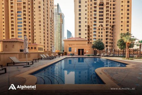 een zwembad in een stad met hoge gebouwen bij Alphatel Beach Hostel JBR in Dubai