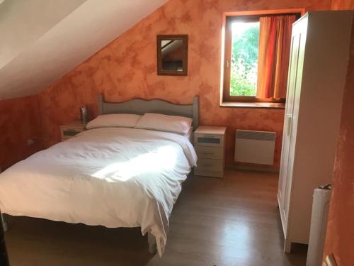 a bedroom with a white bed and a window at Peaceful, comfortable retreat with pool in Montcléra