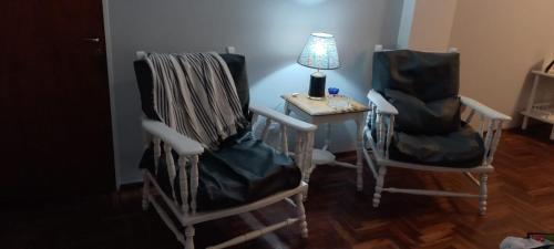 Habitación con 2 sillas y mesa con lámpara. en Departamento Céntrico 2 dormitorios en San Miguel de Tucumán