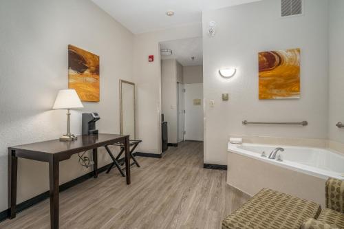 a hotel room with a desk and a bath tub at Best Western Plus Silvercreek Inn in Swansboro