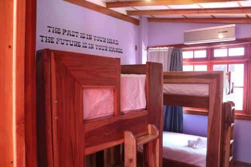 a room with two bunk beds with a sign on the wall at Planet B Hostel - Adults Only in Manuel Antonio