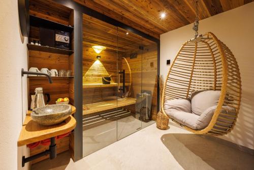 a bathroom with a swing chair in a room at Steinberger Hof in Ruhpolding