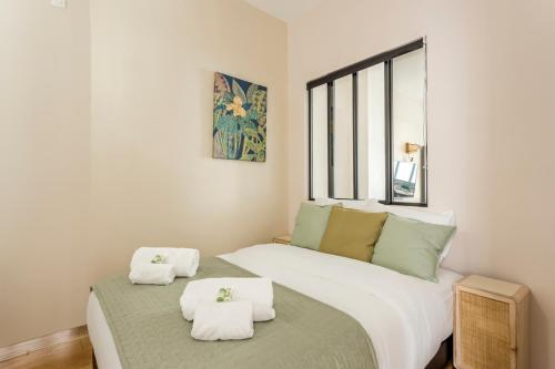 una camera con due letti e asciugamani di Design et confort near Champs Elysees a Parigi