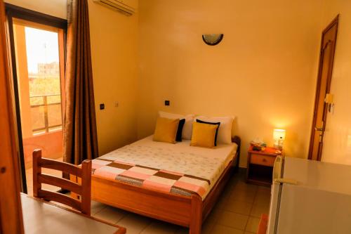 a small bedroom with a bed and a window at AG HOTEL Ouaga in Ouagadougou
