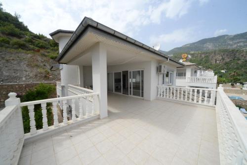 Casa blanca con valla blanca y balcón en Prima 9+2 Villas en Alanya