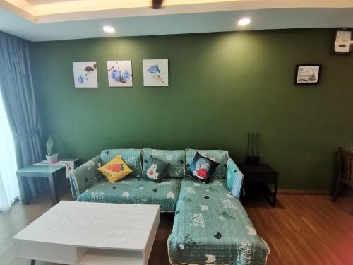 a living room with a green couch with pillows at teo resident 2 vivacity jazz suite 4 in Kuching