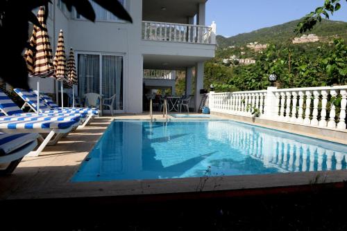 una piscina con tumbonas y un edificio en Prima 9+2 Villas en Alanya