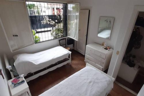 Habitación pequeña con 2 camas y espejo. en Casa Mar del Plata en Mar del Plata