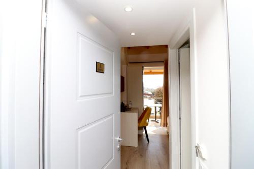 a hallway with a white door and a room at Fegi Rooms in Himare
