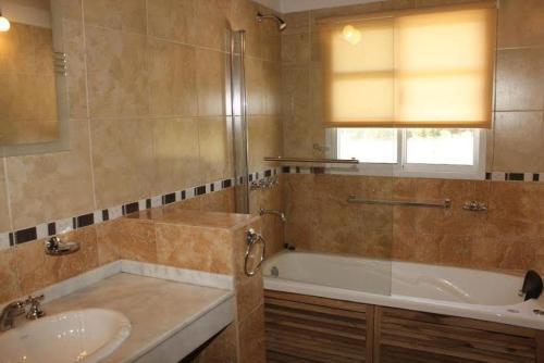 y baño con bañera y lavamanos. en Winds Hill Resort & Spa en Merlo