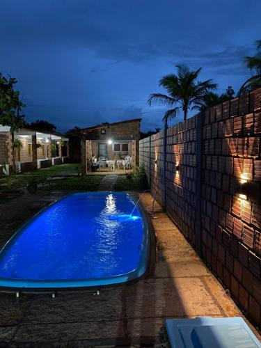 a large blue swimming pool in a backyard at night at Pousada vida nos lençóis in Barreirinhas
