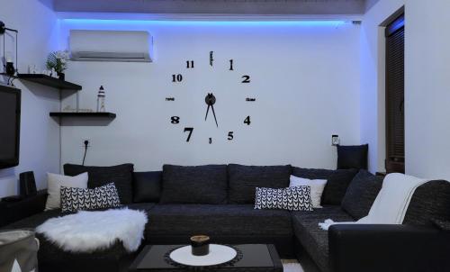 sala de estar con sofá y reloj en la pared en Palatinus Apartman Esztergom, en Esztergom