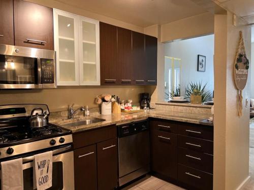 a kitchen with brown cabinets and a stove top oven at Amazing Universal Studios Loft FREE parking in Los Angeles