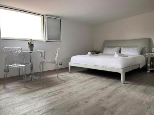 1 dormitorio con 1 cama blanca, mesa y silla en Life is Roma, en Roma