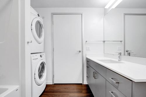 eine weiße Waschküche mit Waschmaschine und Trockner in der Unterkunft Bellevue 1BR w BBQ Gym WD nr Spring District SEA-224 in Bellevue