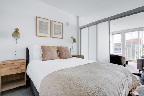 ein Schlafzimmer mit einem weißen Bett und einem großen Fenster in der Unterkunft Bellevue 1BR w BBQ Gym WD nr Spring District SEA-224 in Bellevue