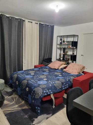 une chambre avec un lit avec une couette bleue dans l'établissement Appartement cosy et équipé, à Meaux