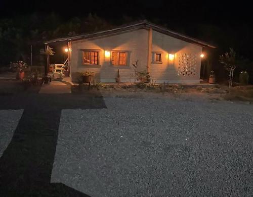 una pequeña casa blanca con luces encendidas por la noche en Privada y comoda cabaña, Casa Margarita, Villavieja, en Villavieja