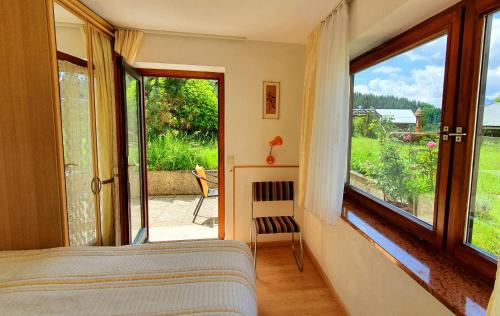 1 dormitorio con cama y ventana grande en 4 Bergpanorama mit herrlicher alpinen Almlandschaft Nichtraucherdomizil, en Schönau am Königssee