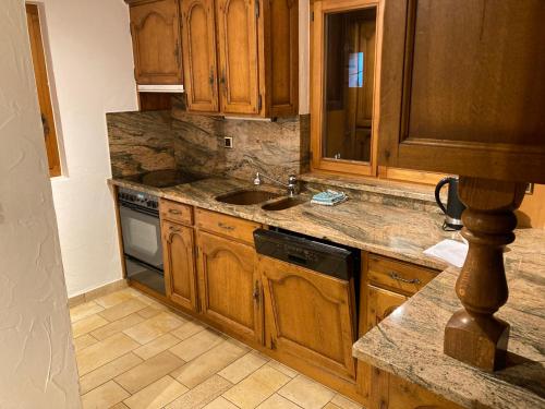 a kitchen with wooden cabinets and a sink at Chalet, Bagnes, Suisse in Le Châble