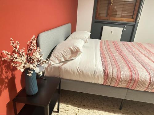 - une chambre avec un lit et une table fleurie dans l'établissement Cappuccini Apartment, à Bergame