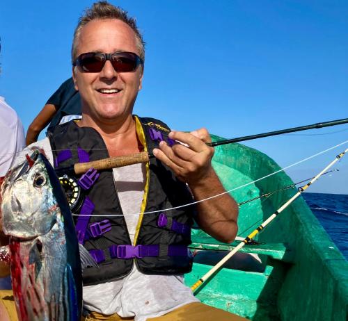 a man holding a fish in a boat at Hotel Tranquilo in Las Peñitas