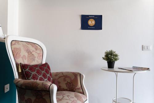 a chair with a pillow sitting next to a table at Domus Karalis in Cagliari