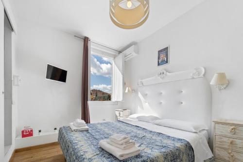 a white bedroom with a bed with towels on it at Domus Karalis in Cagliari