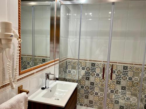 W łazience znajduje się umywalka i prysznic. w obiekcie Hotel El Curro w mieście Burunchel