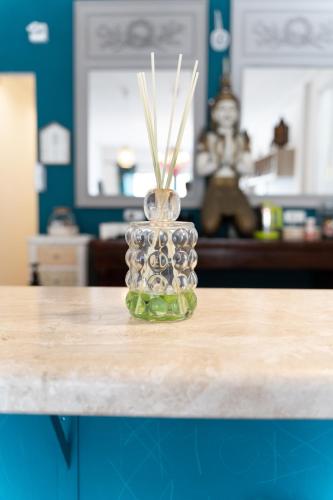 a glass vase with grasses in it sitting on a table at Domus Karalis in Cagliari