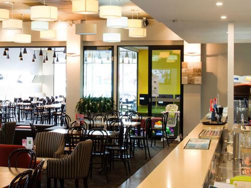 un restaurante con mesas y sillas y un bar en The Oaks Hotel Motel, en Albion Park