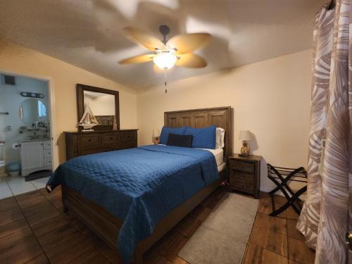 a bedroom with a blue bed and a ceiling fan at Old Town Suites in Key West