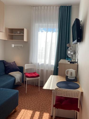 a small living room with a blue couch and a table at Villa Baltic Chałupy - Apartament nr 14A in Chałupy
