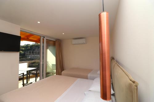 a bedroom with a bed and a balcony with a table at Fegi Rooms in Himare