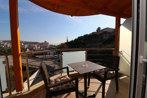 a table and chairs on a balcony with a view at Fegi Rooms in Himare