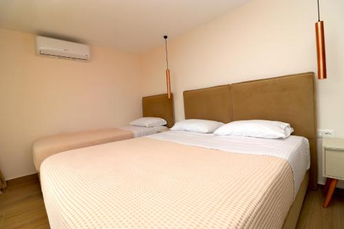 two beds in a small room with twoermottermott at Fegi Rooms in Himare