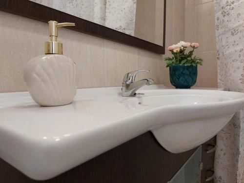 a white bathroom sink with a soap dispenser on it at Apartamento con vistas al mar. in Salobreña
