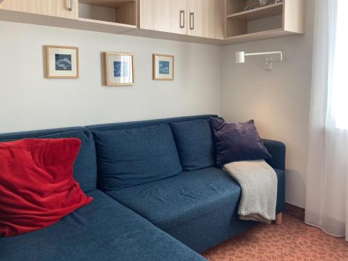 a blue couch with two pillows in a living room at Villa Baltic Chałupy - Apartament nr 14A in Chałupy