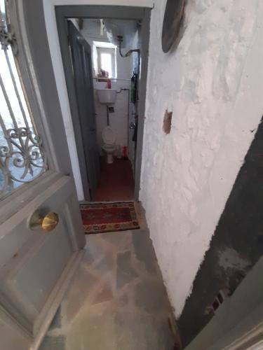 a hallway of a bathroom with a toilet and a door at Maison charmante in Hydra