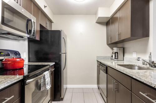 a kitchen with a black refrigerator and a sink at Cupertino 2BR w Gym Pool nr Apple Google SFO-310 in Cupertino