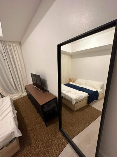 a mirror in a bedroom with a bed and a bed sqor at The Patio at Monaco Tower in Lagundi