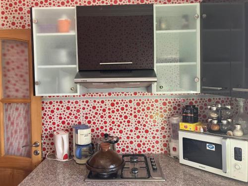 a kitchen with a stove and a microwave at Bel Appartement à Proximité de la Gare Routière in Agadir