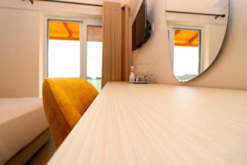 a dressing table with a mirror and a yellow chair at Fegi Rooms in Himare