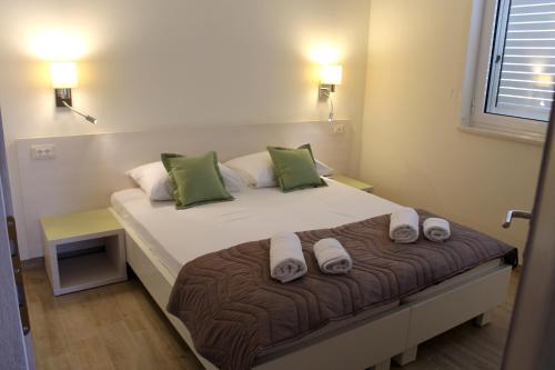 a bedroom with a large bed with green pillows at Apartments Lavanda in Budva