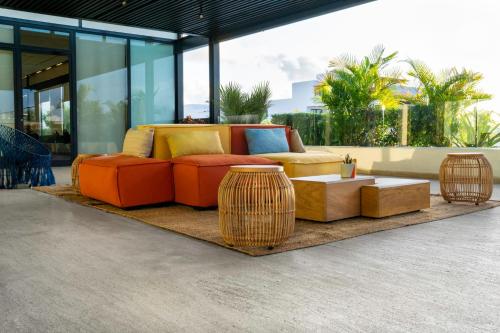 a living room with a couch and tables on a rug at Fiesta Inn Playa del Carmen in Playa del Carmen
