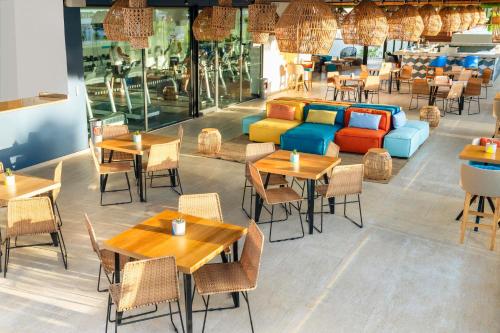 a restaurant with tables and chairs and a couch at Fiesta Inn Playa del Carmen in Playa del Carmen