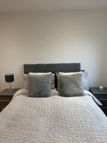 um quarto com uma cama grande e almofadas em Stunning 2 bed/2 bath Apartment em Warlingham