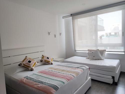 2 camas en una habitación blanca con ventana en Spiaggia di Cartagena (Apartamento de lujo), en Cartagena de Indias